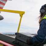 female agent unloading baggage from ramp