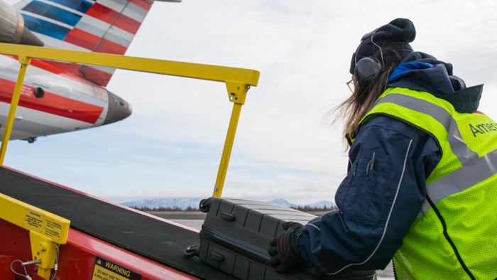 female agent unloading baggage from ramp