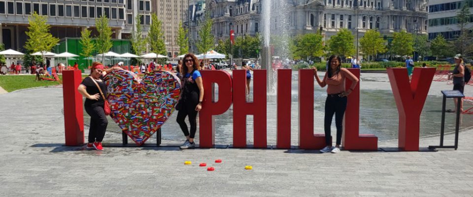 Envoy team members pose with "I love philly" sculpture