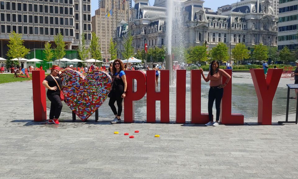 Envoy team members pose with "I love philly" sculpture