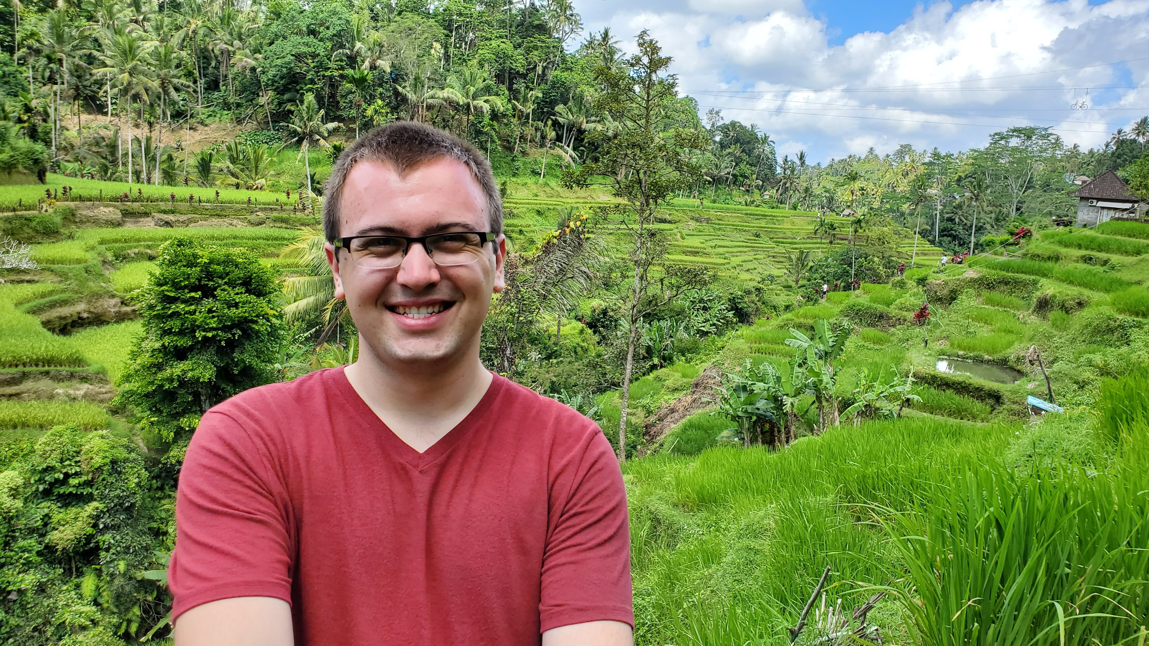 Kevin posing in front of a rice paddie field in Bali. 