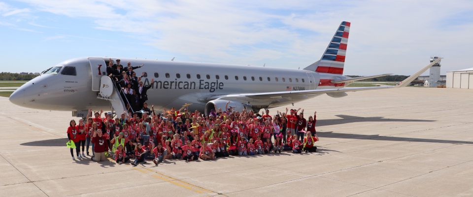 Team Envoy and group of girls pose in front of an Envoy E175 at Purdue University Airport for Girls in Aiviation Day