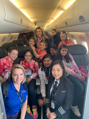 A group of girls pose onboard an Envoy E175 at Purdue Girls in Aviation Day 