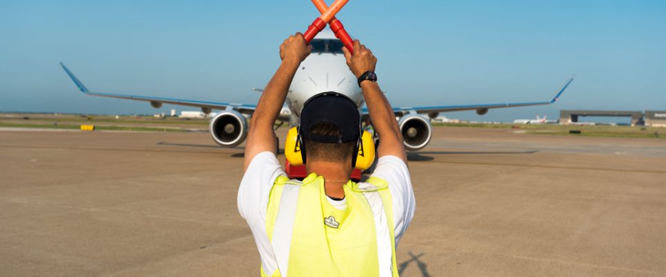 Fleet Service Clerk guiding plane on the ramp