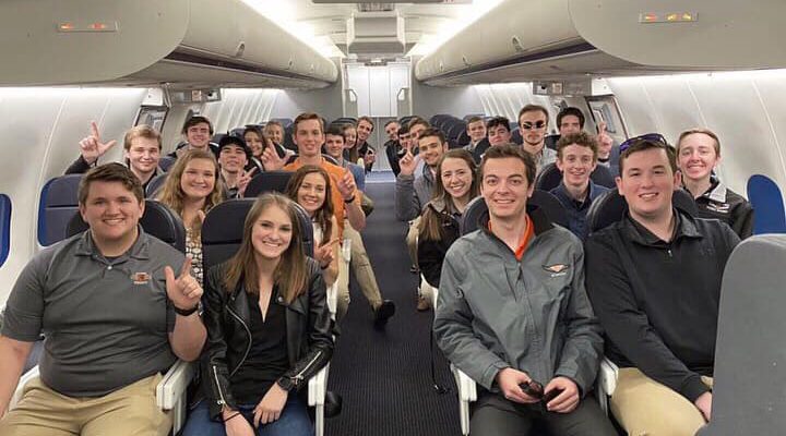 Flying Aggies students pose on a cabin trainer