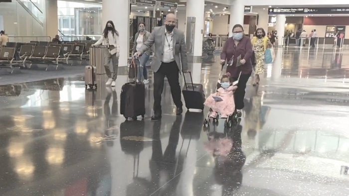 Envoy Special Services managers Luis Carrodeguas and Marisela Rafuls wheel Kristen  and her luggage in the Miami International Airport terminal.